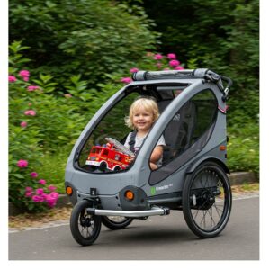 "A child sitting comfortably in an ebike trailer, enjoying a ride with a toy in hand."