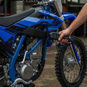 "An adult connecting a charger to their electric dirt bike for adults."