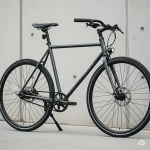 A minimalist and clean belt drive commuter bike parked against a wall, emphasizing its sleek aesthetic and lack of greasy components.