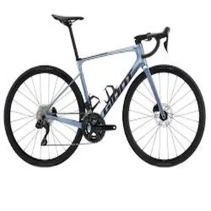  A giant defy road bicycle on a gravel road, showcasing its versatility and capability for different types of terrain.