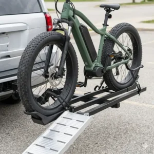A large fat-tire electric bike securely mounted on a hitch bike rack with ramp anti wobble using the ramp.