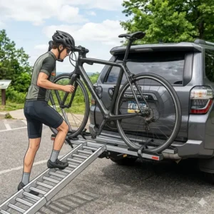 A cyclist using the loading system of the hitch bike rack with ramp for road bikes to easily position a bike.
