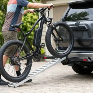 A person loading an electric bike onto a hitch bike rack with ramp under $1000.